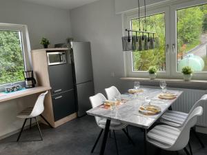 een keuken met een tafel met stoelen en een koelkast bij FERIENWOHNUNG AM BERG in Marktgraitz
