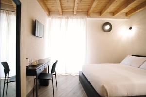 1 dormitorio con cama, escritorio y ventana en Casa Marinari, en Scalea