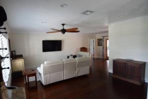a living room with a couch and a ceiling fan at Bright and cheerful 4 bedroom home pool in Boca Raton