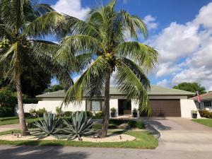 two palm trees in front of a house at Bright and cheerful 4 bedroom home pool in Boca Raton