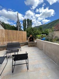 a patio with two benches and a fire pit at Agréable T2 idéalement situé in Mende