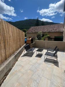 a patio with three chairs and a fence at Agréable T2 idéalement situé in Mende