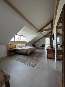 een slaapkamer met een groot bed op zolder bij Hoeve BuytenHout in Delft