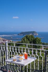 a table on a balcony with a view of the ocean at RIAMA AGRIRESORT in Naples