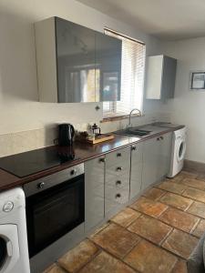 a kitchen with a sink and a stove top oven at The Haven in Portreath