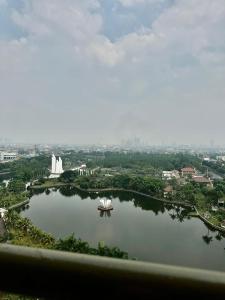 a view of a large lake with a white fountain at Apartemen Green Palace View Kalibata in Jakarta