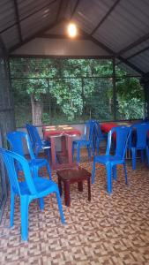 a group of blue chairs and tables in a patio at Wild Window - Forest View Homestay in Thekkady