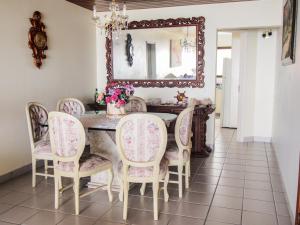 een eetkamer met een tafel met stoelen en een spiegel bij Sorocotuba 2 - Enseada in Guarujá