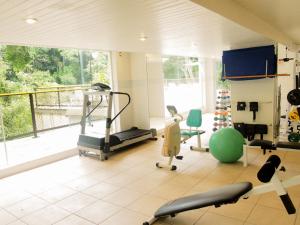 a gym with cardio equipment and a large window at Sorocotuba 2 - Enseada in Guarujá