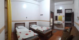 una camera con due letti e un lavandino in esso di WISMA SIBAYAK Guesthouse BERASTAGI a Berastagi