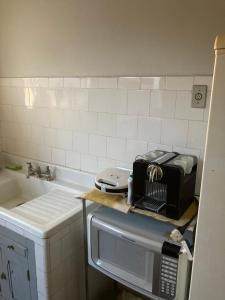 uma cozinha com uma torradeira num balcão ao lado de um lavatório em Apto Hiper centro diamantina em Diamantina