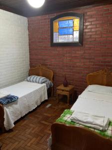迪亞曼蒂納的住宿－Apto Hiper centro diamantina，一间设有两张床和砖墙的房间
