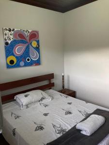 1 dormitorio con 1 cama con una pintura en la pared en Apto Hiper centro diamantina, en Diamantina