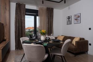 una sala da pranzo con tavolo, sedie e divano di Apartment Artemis Zadar a Zara (Zadar)