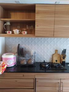 a kitchen with a counter top with utensils at Apartemen Green Palace View Kalibata in Jakarta