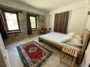 a bedroom with a bed and a table and windows at AGON Ephesus in Selçuk