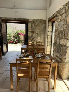 a table and chairs in a room with a stone wall at AGON Ephesus in Selçuk