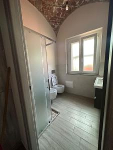 baño con aseo y ventana en Residenza Zotaj Small appartament, en Casale Monferrato