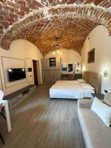 Habitación grande con 2 camas y sofá en Residenza Zotaj Small appartament, en Casale Monferrato