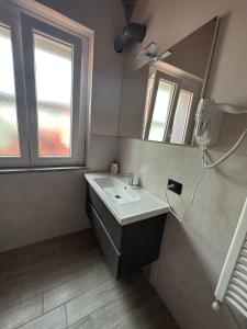 y baño con lavabo y espejo. en Residenza Zotaj Small appartament, en Casale Monferrato