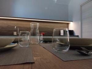quatre verres à vin vides assis sur une table en bois dans l'établissement Casetta San Marciano Pile, à LʼAquila
