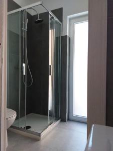 La salle de bains est pourvue d'une douche en verre et de toilettes. dans l'établissement Casetta San Marciano Pile, à LʼAquila