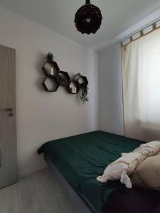 ein Schlafzimmer mit einem grünen Bett und einem Fenster in der Unterkunft Przytulne mieszkanie przy Kanale Żerańskim in Warschau