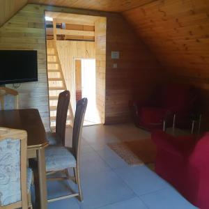 una habitación con mesa y sillas en una cabaña en Domek Pod Akacjami en Szypliszki