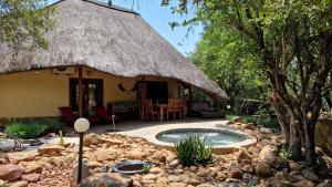 a hut with a pool in the middle of a yard at Bona Intaba Game Lodge in Hoedspruit