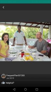 a group of people sitting around a table with food at Anura Home Stay in Kalutara