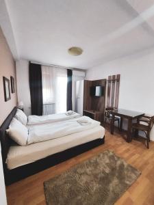 a bedroom with a large bed and a desk at Vila Papu in Kruševo