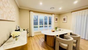 a dining room with a table and chairs and a window at Peaceful Sanctuary in Pennant Hills