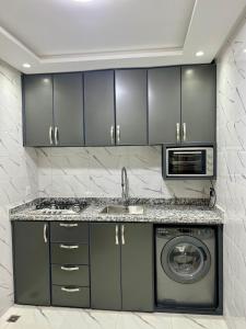 a kitchen with a washing machine and a microwave at Duplex familial 3 chambres au cœur de la Corniche de Tanger in Tangier