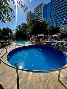 Duplex familial 3 chambres au cœur de la Corniche de Tanger في طنجة: مسبح ازرق كبير مع مباني في الخلف