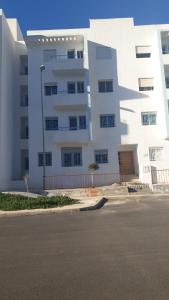 a large white building next to a street at Dar l Bihar in Al Hoceïma +6 photos