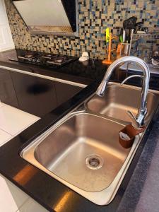 a stainless steel sink in a kitchen at Pelita Commercial Centre Homestay 百丽达商圈民宿 9pax in Miri +35 photos