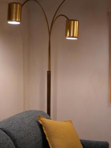 a lamp in a room with a couch and a pillow at La Bartolomea Home & Suite in Pitigliano