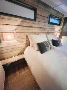 a bed in a room with a wooden wall at Trendy House Hattem nr4 in Hattemerbroek