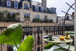 Avalon Cosy Hotel Paris في باريس: طاولة على شرفة أمام المبنى