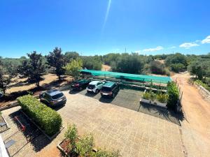 Un estacionamiento con autos estacionados frente a una gasolinera. en Uacella, en Locorotondo