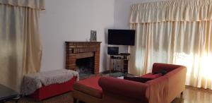 sala de estar con sofá y chimenea en BELLA CASA EN VILLA LIBERTAD en Leandro N. Alem