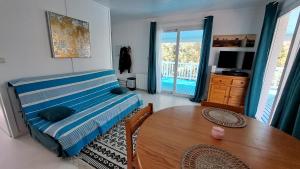 a bedroom with a bed and a table and a balcony at La Jenny Village Naturiste - chalet 4/6 personnes in Le Porge