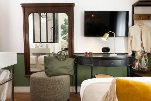 1 dormitorio con cama, silla y espejo en Avalon Cosy Hotel Paris, en París