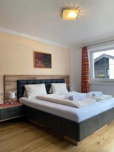 ein großes Bett in einem Schlafzimmer mit Fenster in der Unterkunft Appartements Konrad in Söll