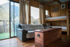 a room with a couch and a bed and a table at McBains in Breerivier +161 photos