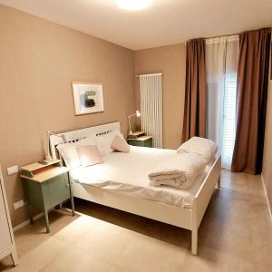 ein Schlafzimmer mit einem weißen Bett und einem Fenster in der Unterkunft Casa Franciacorta in Gussago