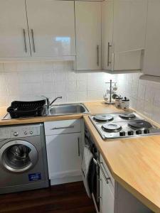 a kitchen with a sink and a washing machine at Royal Apartments Edinburgh in Edinburgh