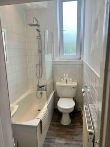 a bathroom with a toilet and a tub and a sink at Royal Apartments Edinburgh in Edinburgh