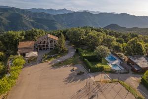 an aerial view of a building with a pool and mountains at Camping Susen in Saldés