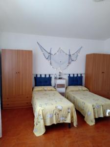 una camera con 2 letti e armadi in legno di Appartamento Marina di Pisticci-Marconia a Marconia